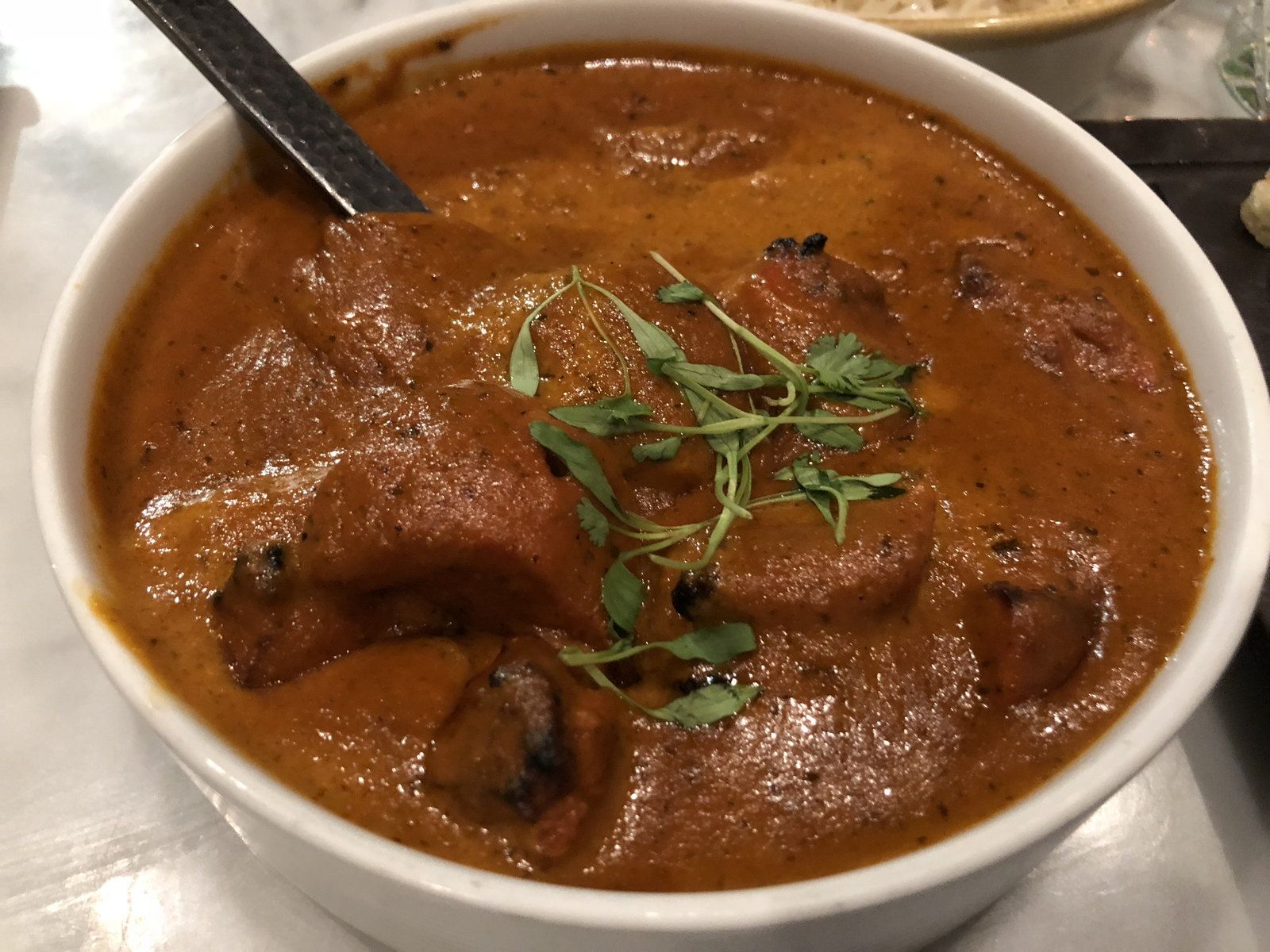 Butter chicken in a bowl, finished with cream and fresh coriander